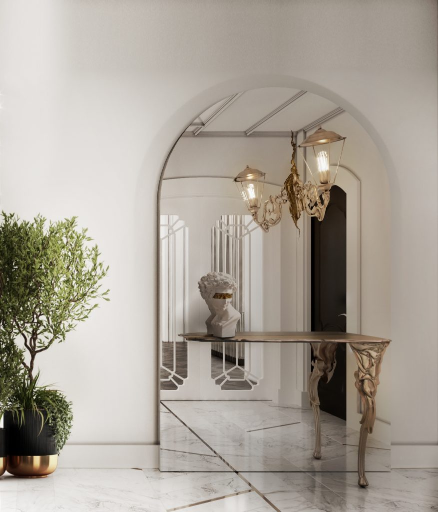 contemporary and exquisite luxury golden console composed by a large mirror and a lamp with a sculpture on a white wall and a plant