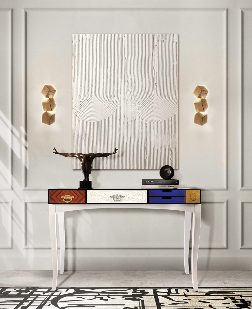 contemporary luxury white console table with drawers with color on a white wall, golden lamps and a black and white rug